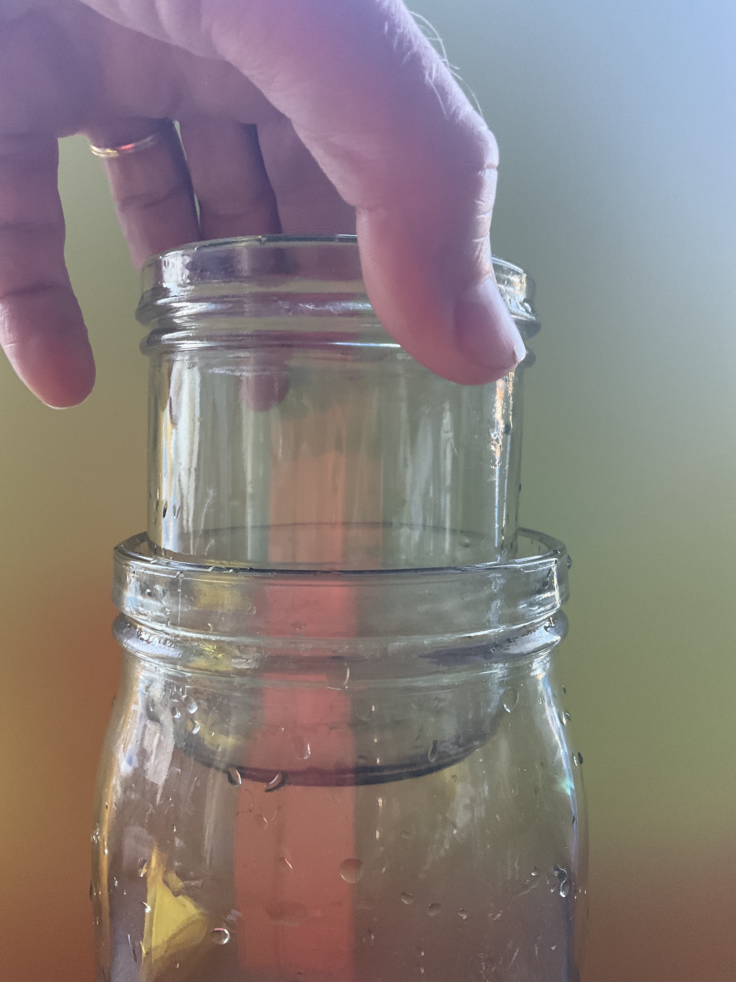 A hand holding a jar inside a jar